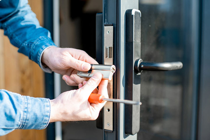 a person using a screwdriver to fix a hinge