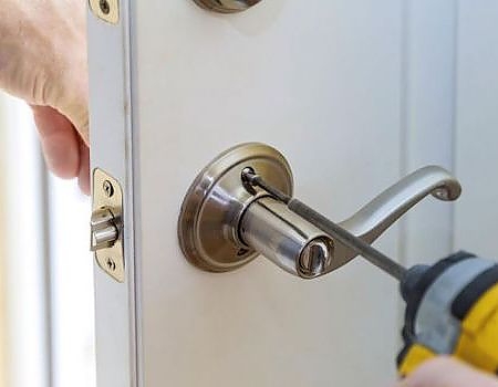 man holding lock repair tools near a door